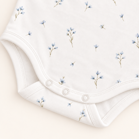 Detalle broches y estampado Detalle broches libres de níquel y estampado floral azul en body algodón Pima para bebé – Rikury