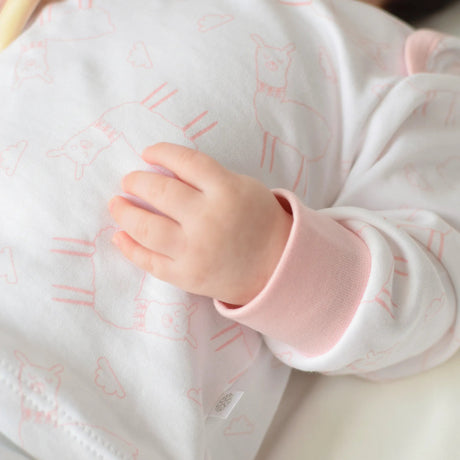 Detalle de polo pijama llamita rosa de algodón pima para bebé