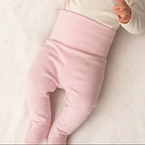 bebé acostada con pantalón rosa puesto: Bebé usando pantalón pretina ancha rosa – pancita cómoda sin presión, algodón Pima | Rikury