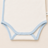 Detalle tiro body ivory con collareta celeste y broches libre de níquel — algodón Pima peruano | Rikury Baby