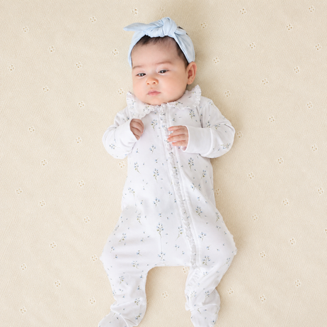 Bebé acostada con enterizo puesto Bebé niña recién nacida con Enterizo Floral y vincha celeste — algodón Pima suave | Rikury Baby
